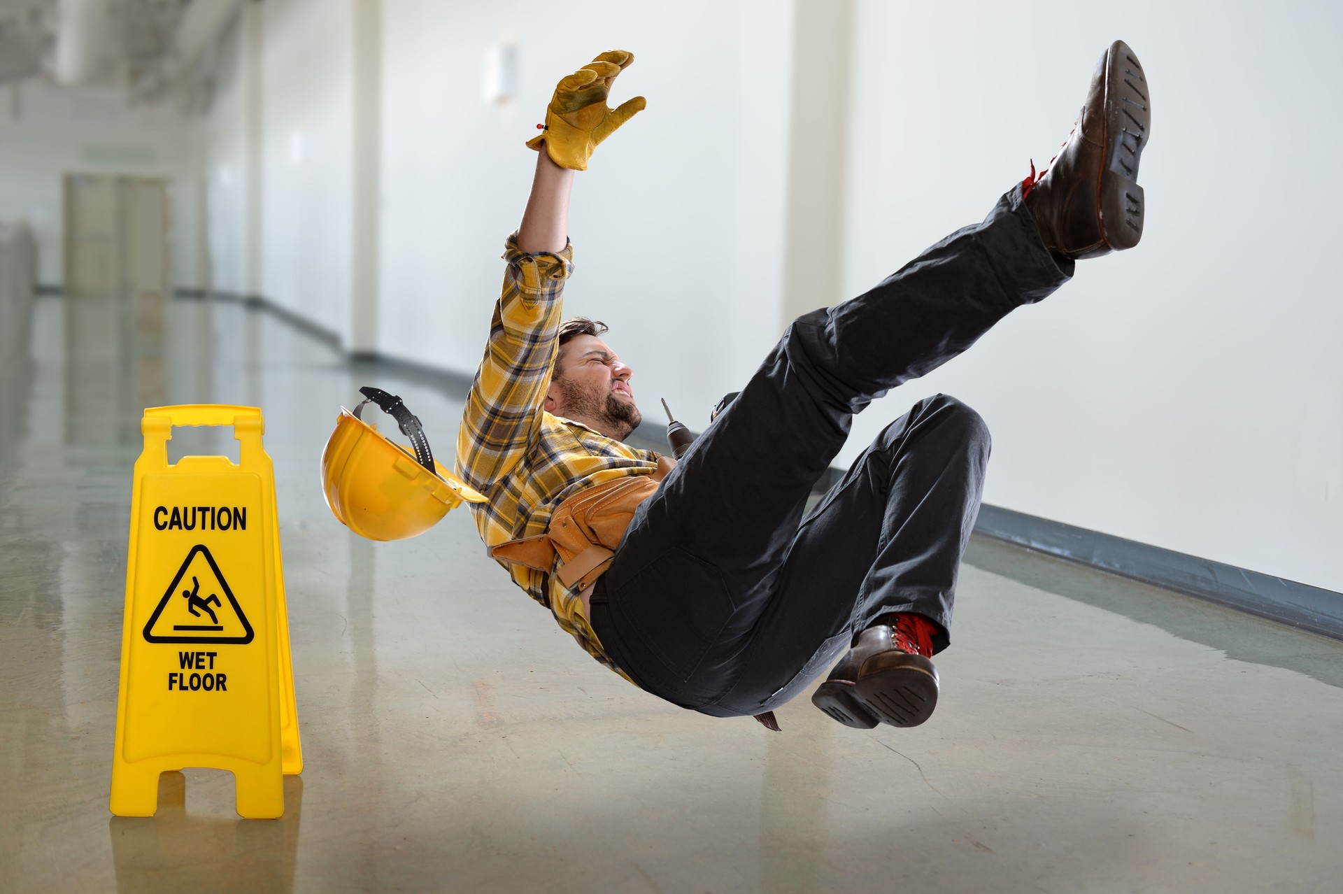 Trabajador cayendo en piso mojado